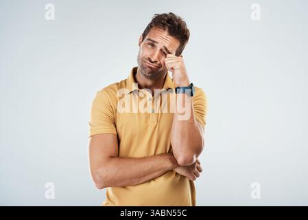 Triste, ritratto e uomo che piange in studio per offesa, arrabbiato e spaventato espressione del volto per depressione. Infelice, dolore e uomo con lacrime per Foto Stock