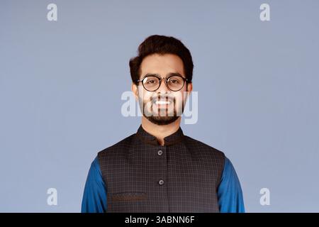 Uomo indiano sorridente che indossa occhiali eleganti su sfondo lilla Foto Stock