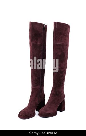 Eleganti stivaletti da donna scamosciati con tacco rosso e punta quadrata su sfondo bianco. Scarpe invernali in pelle da donna con eleganti tacchi e fibbie. Foto Stock