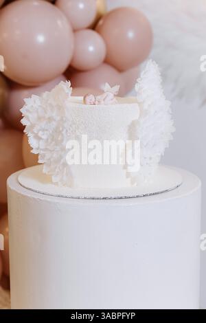 Questa torta bianca assolutamente sbalorditiva, adornata da bellissimi e delicati fiori, è perfetta per matrimoni, anniversari o qualsiasi elegante festa Foto Stock