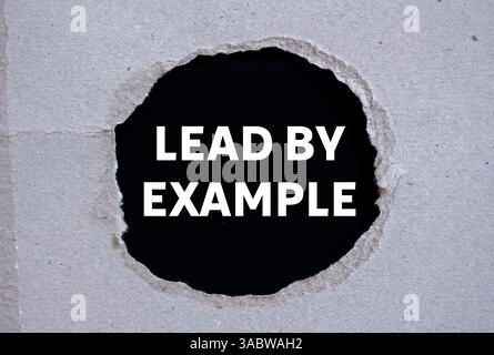 Messaggio di esempio scritto su carta strappata su sfondo nero. Guida concettuale con simbolo di esempio. Copia spazio. Foto Stock