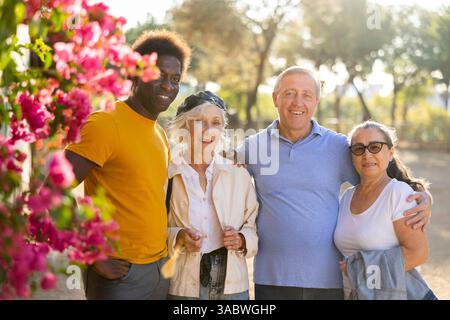 Ritratto di felice multirazziale amichevole adulto persone in piedi all'aperto legame e posa Foto Stock