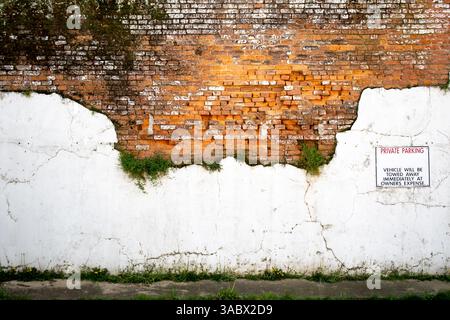 Cartello di parcheggio privato sul vecchio muro di mattoni Foto Stock