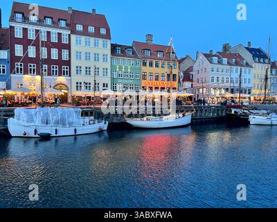Nyhavn (Porto nuovo) è un lungomare del XVII secolo, un canale e un quartiere dei divertimenti a Copenaghen. È stata presa al crepuscolo con le luci riflesse nell'acqua Foto Stock