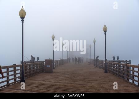 Oceanside, California - 3 gennaio 2025: Tranquilla mattinata nebbiosa presso il molo municipale di Oceanside con pescatori e piacevoli passeggiate sul ponte di legno Foto Stock
