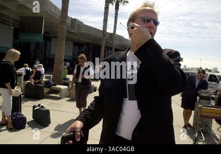 (Pubblicato il 08/07/2003, A-1, UTS1752407; SignOn: 08/07/2003; SignOn Weekly Gallery: 08/11/2003): Il musicista della Three Dog Night Paul Kingery di Detroit, Michigan, parla sul suo cellulare per dirigere un autista che lo ha lasciato bloccato al Lindbergh Field quando il suo bagaglio è stato ritardato. Kingery era a San Diego per uno spettacolo con il concerto della San Diego Symphony Summer Pops al Navy Pier.--Laura Embry/Union-Tribune Foto Stock