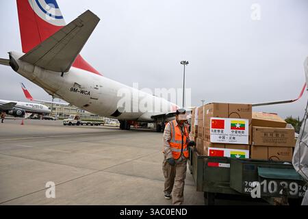Kunming, Cina. 2 aprile 2025. I membri del personale caricano materiali di soccorso su un volo all'aeroporto internazionale Kunming Changshui di Kunming, capitale della provincia dello Yunnan, nella Cina sud-occidentale, 2 aprile 2025. Il volo che trasporta circa 19 tonnellate di articoli di soccorso, tra cui medicinali, materiali per l'igiene e la prevenzione delle epidemie, tende, coperte e vestiti, parte da Kunming alle 12:45 di questo giorno e dovrebbe arrivare a Nay Pyi Taw dopo due ore. È stato il quarto lotto di rifornimenti dalla provincia dello Yunnan al Myanmar dopo il massiccio terremoto che ha colpito il paese del sud-est asiatico il 2 marzo Foto Stock