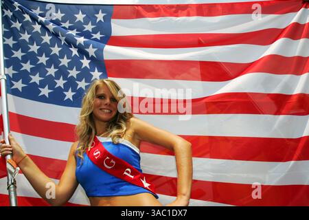 Le "ragazze della griglia" fanno parte degli sport motoristici internazionali tanto quanto il carburante ad alto numero di ottani, i tappi per le orecchie e gli incidenti ardenti. Prima di ogni gara, le ragazze della griglia prendono posizione dietro la linea di partenza, tenendo la bandiera nazionale della squadra e il numero del veicolo, o tenendo gli ombrelli sopra i piloti rivestiti in pelle per tenere il sole lontano da loro sull'asfalto bruciante. Inoltre, a quanto pare, passano un bel po' di tempo a stare in giro e a sembrare assurdamente caldi. A lungo, possano agitare. Nella foto: Grid Girl...Formula 1 World Championship, Rd 7, United States Grand Prix, Race, Indianapolis, USA, domenica 17 giugno 2007.(C Foto Stock