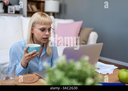 Giovane insegnante educata che insegna ai bambini della scuola online su computer portatile e videochiamata. E-learning, educatrice a distanza che aiuta i giovani studenti Foto Stock
