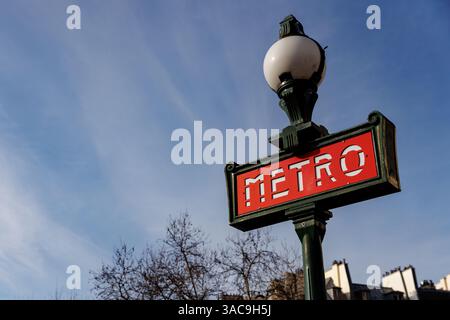 Un segno rosso e bianco con sopra la parola Metro. Il cartello è su un palo verde. Il cielo è blu Foto Stock