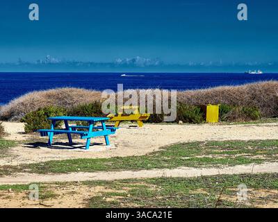 Panchine da picnic sulla spiaggia con vista sul mare sull'isola di Malta Foto Stock