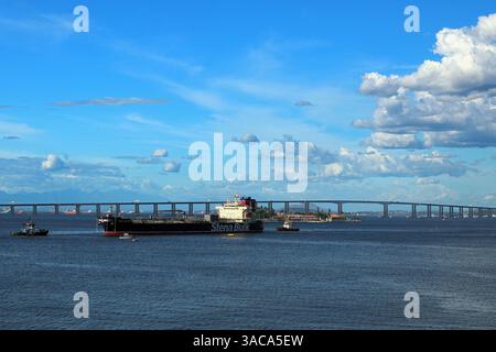 Nave petroliera e chimichiera di fronte al ponte Rio Niterói o Ponte Rio Niterói, che attraversa la baia di Guanabara tra Rio de Janeiro e Niterói in Brasile Foto Stock