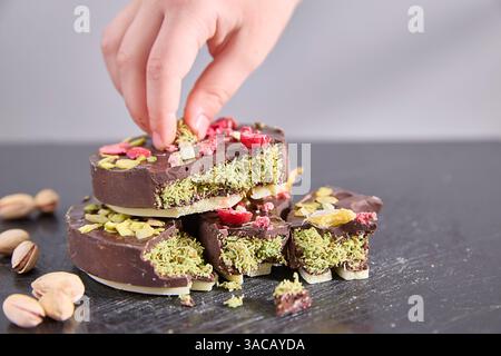 Cioccolato di Dubai. Croccanti scaglie di cioccolato richiamano da uno sfondo ardesia, offrendo un momento di divertimento tranquillo e lussuoso, perfetto per illustrare l'arte Foto Stock
