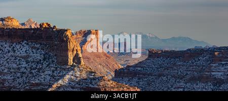 L'ultima luce del tramonto vicino al Wedge Overlook, nella zona settentrionale di San Rafael nello Utah. La neve copriva le Henry Mountains si innalzano in lontananza. Foto Stock