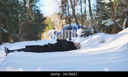 Mamma e bambino si divertono in una foresta innevata in una splendida giornata invernale, godendosi del prezioso tempo in famiglia Foto Stock