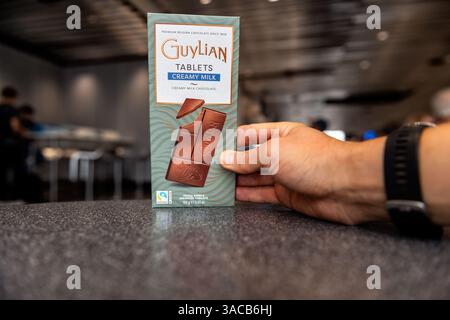 Francoforte, Germania - 28 agosto 2023: Barretta di cioccolato belga al latte guyliano cremoso a mano in mano in aeroporto Foto Stock