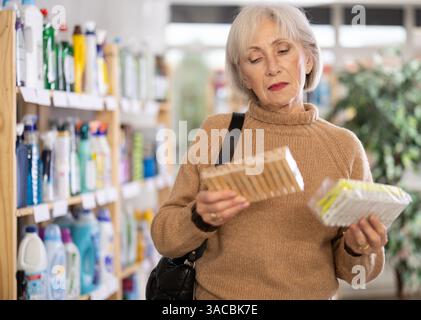 Donna che sceglie un set di clothespins nel negozio Foto Stock
