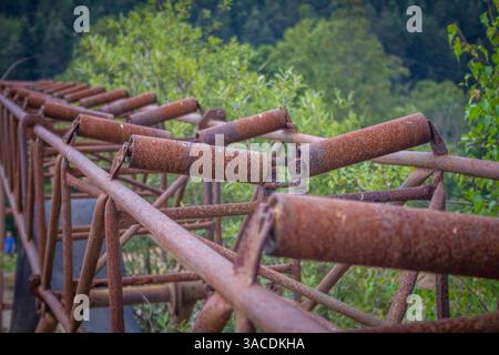 La struttura metallica è vecchia e presenta molta ruggine. Si tratta di un ponte o di un tipo simile di struttura. La ruggine conferisce alla struttura un ap usurato e invecchiato Foto Stock