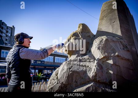 DEN HAAG - Un produttore lavora su una scultura di sabbia sul viale di Scheveningen. Per la prima volta in 15 anni, questa mostra all'aperto di opere di sabbia è tornata a Scheveningen. ANP ROBIN UTRECHT netherlands Out - belgio Out Foto Stock