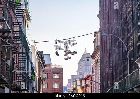 Scarpe e sneakers appese a una linea a New York City Foto Stock