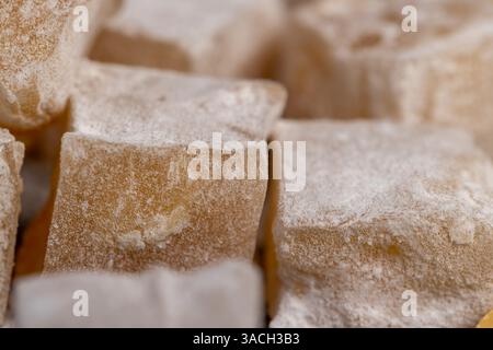 Delizia turca con noci, dolci orientali sparsi delizia turca con arachidi su una tavola di ardesia nera, vista ravvicinata, laterale Foto Stock