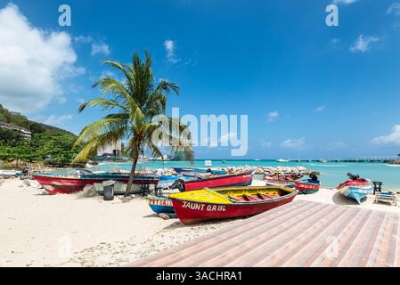 Ocho Rios, Giamaica - 9 aprile 2024: Barche da pesca fiancheggiano la spiaggia di Ocho Rios, una popolare destinazione turistica in Giamaica, con una nave da crociera ormeggiata a nea Foto Stock