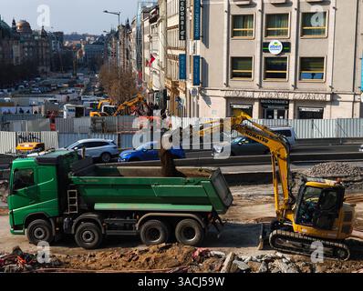 Praga, Repubblica Ceca - 25 marzo 2025: L'escavatore komatsu carica un camion con lo sporco durante i lavori di costruzione di strade in piazza venceslao, praga, cz Foto Stock