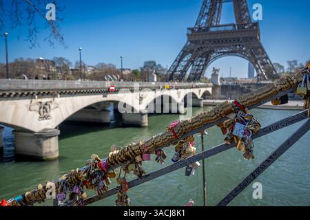 Parigi, Francia - 03 31 2025: Banchine della Senna. Vista di una ringhiera piena di lucchetti per gli amanti, Torre Eiffel e Ponte Iena dietro Foto Stock