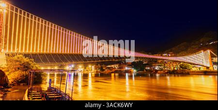 Ponte RAM Jhula illuminato di notte a Rishikesh, India Foto Stock