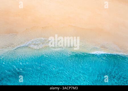 Fantastica vista aerea dall'alto della splendida spiaggia tropicale di sabbia bianca con schiuma ondulata e mare trasparente, spazio per le copie delle vacanze estive e dei viaggi Foto Stock