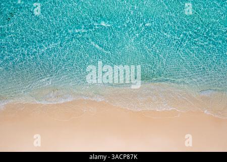 Fantastica vista aerea dall'alto della splendida spiaggia tropicale di sabbia bianca con schiuma ondulata e mare trasparente, spazio per le copie delle vacanze estive e dei viaggi Foto Stock