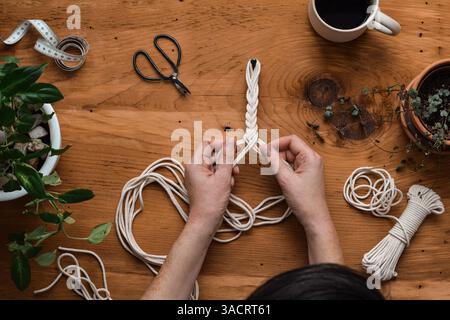 Vista dall'alto verso il basso della donna che produce un gancio per piante di macrame Foto Stock