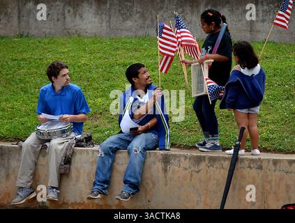 5 gennaio 2012 - Charlotte, North Carolina, USA - Venus Betancourt, 9 anni, seconda da destra, consegna le bandiere americane alle persone riunite al Marshall Park lunedì 1 maggio 2017 a Charlotte, N.C. (immagine di credito: © Jeff Siner/TNS via ZUMA Wire) Foto Stock
