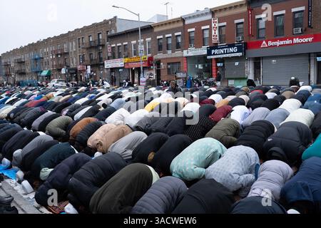 Uomini musulmani pregano su Eid su McDonald Ave a Brooklyn NY, nel quartiere "Little Bangladesh" di Kensington. EID al-Fitr 'festa della rottura del digiuno') è un'importante festa religiosa celebrata dai musulmani in tutto il mondo che segna la fine del Ramadan, il mese sacro islamico del digiuno (sawm). Foto Stock