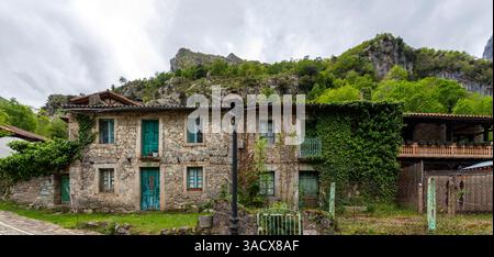 Case pittoresche nel villaggio di Caino de Valdeon, alla fine del sentiero escursionistico della gola di Cares nei monti Picos de Europa nelle Asturie, nel nord della Spagna Foto Stock