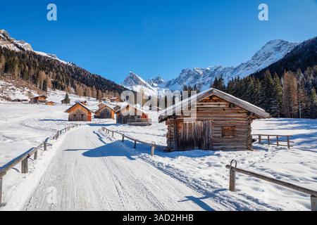 Piccolo borgo alpino con tradizionali capanne in legno in Val San Nicolò, Pozza di Fassa, provincia autonoma di Trento, Dolomiti, Italia Foto Stock