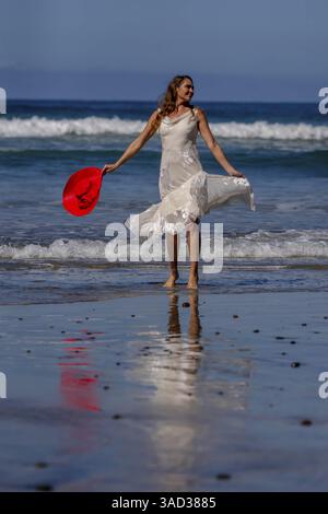 Una donna mozzafiato si crogiola nella beatitudine della spiaggia, vicino a un molo, sotto cieli azzurri, abbracciando la serenità di una giornata perfetta in riva al mare, la Jolla, United sta Foto Stock