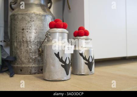 Due latticini in metallo con decorazioni rosse e motivi di cervo in piedi sul pavimento, Centro informazioni turistiche vitello, Foresta Nera, Germania, Europa Foto Stock