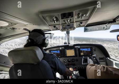 Cockpit Cesna Caravan con pilota in avvicinamento a Airstrip, vista aerea del delta di Okawango, riserva di caccia di Moremi, Delta di Okavango, Maun, Botswana, Africa Foto Stock