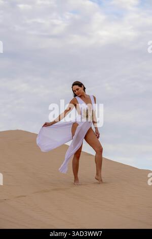 Il modello grazioso abbraccia la bellezza della natura tra le dune di sabbia, incarnando l'eleganza sullo sfondo di un vasto e naturale splendore, Jacumba, Stati Uniti Foto Stock