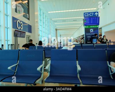 Aeroporto internazionale Manuel Crescencio Rejón a Merida, Yucatan, Messico; vista interna dell'area di attesa passeggeri al gate C3 con monitor e cartelli. Foto Stock