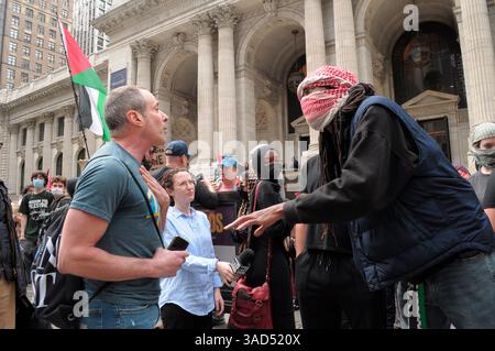 Un manifestante pro-Palestina parla con un manifestante pro-Israele (L) durante una manifestazione pro-Palestina al di fuori della New York Public Library. I manifestanti pro-palestinesi a Manhattan, New York, hanno condannato le forze di difesa israeliane per le sue operazioni militari a Gaza. I manifestanti, alcuni dei quali sono studenti universitari, chiesero alle università di tagliare le loro relazioni commerciali con lo stato di Israele. Israele ha detto che espanderà la sua campagna militare a Gaza e inizierà ad aggiungere grandi territori a Gaza alle zone di sicurezza di Israele. Foto Stock
