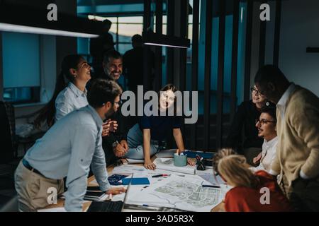 Diversi gruppi di persone aziendali si riuniscono intorno a un tavolo, scambiando idee per un progetto. Foto Stock