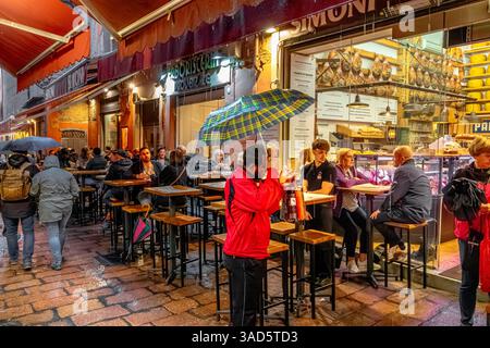 Persone sedute fuori Simoni, un ristorante italiano di salumi o salumi in via Pescherie vecchie a Bologna, Italia Foto Stock
