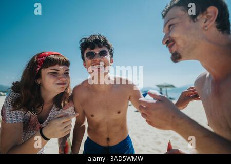 Tre amici che si divertono insieme durante l'estate in spiaggia Foto Stock