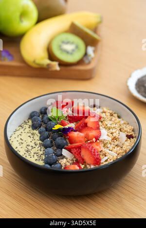 Sana prima colazione con frullato di avocado con frutta fresca e semi di chia su un tavolo di legno Foto Stock