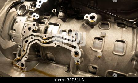 L'olio scorre attraverso i canali di un monoblocco, evidenziando la complessa progettazione e l'ingegneria di precisione della tecnologia automobilistica Foto Stock