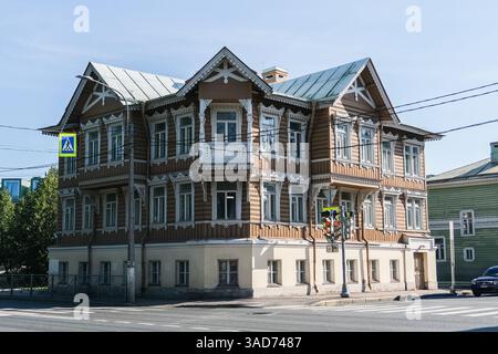 Un grande edificio marrone con un cartello blu sul lato. L'edificio ha molte finestre e un balcone Foto Stock