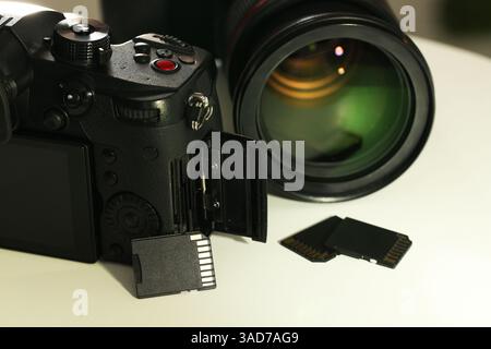 Schede di memoria SD e fotocamere su tavolo bianco, primo piano Foto Stock