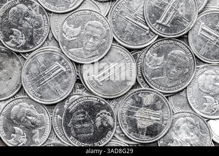 Mucchio di monete indonesiane da 1000 rupie. Vista inversa delle monete della Rupia indonesiana in primo piano Foto Stock